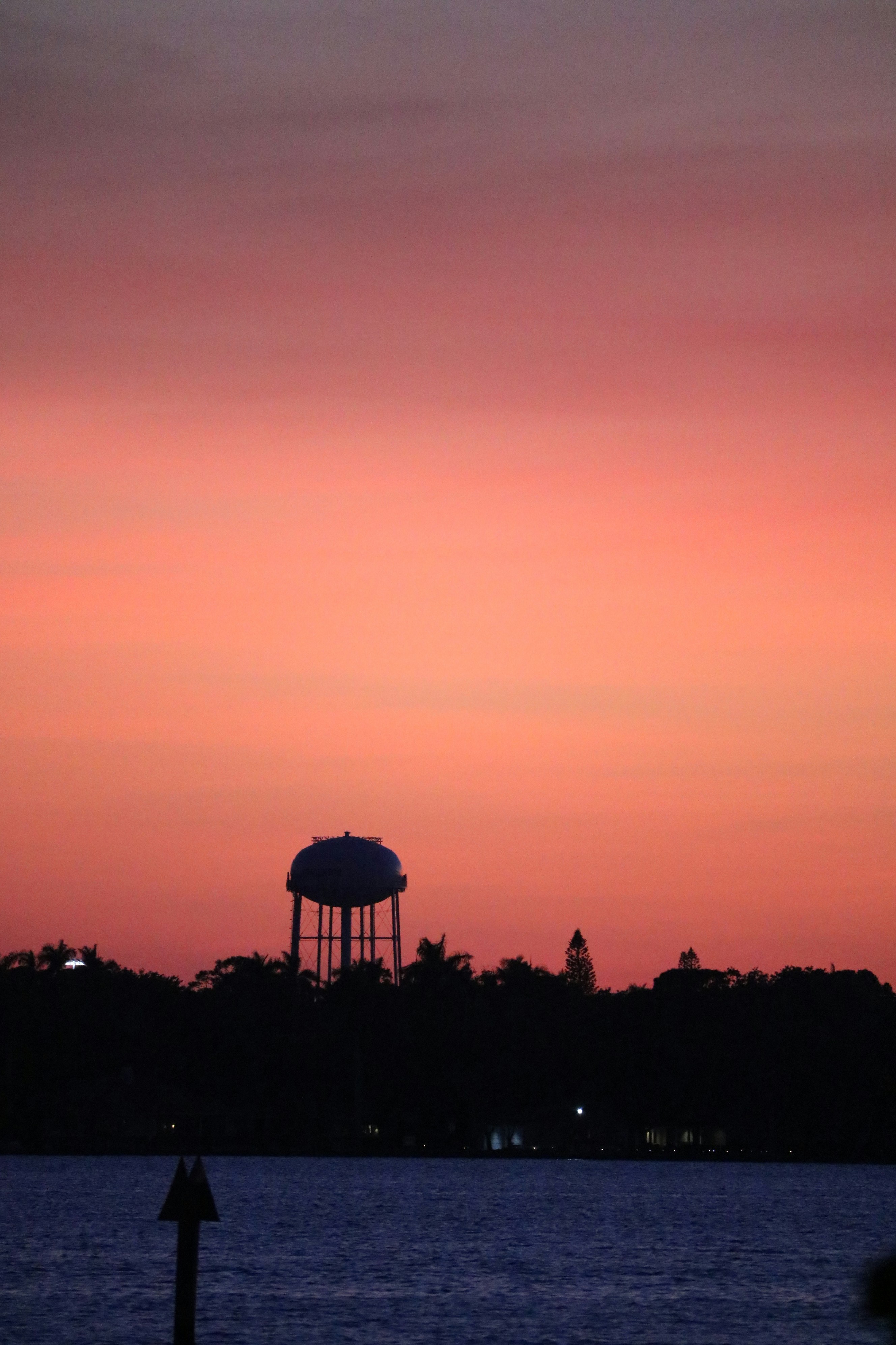 a large body of water with a water tower in the background