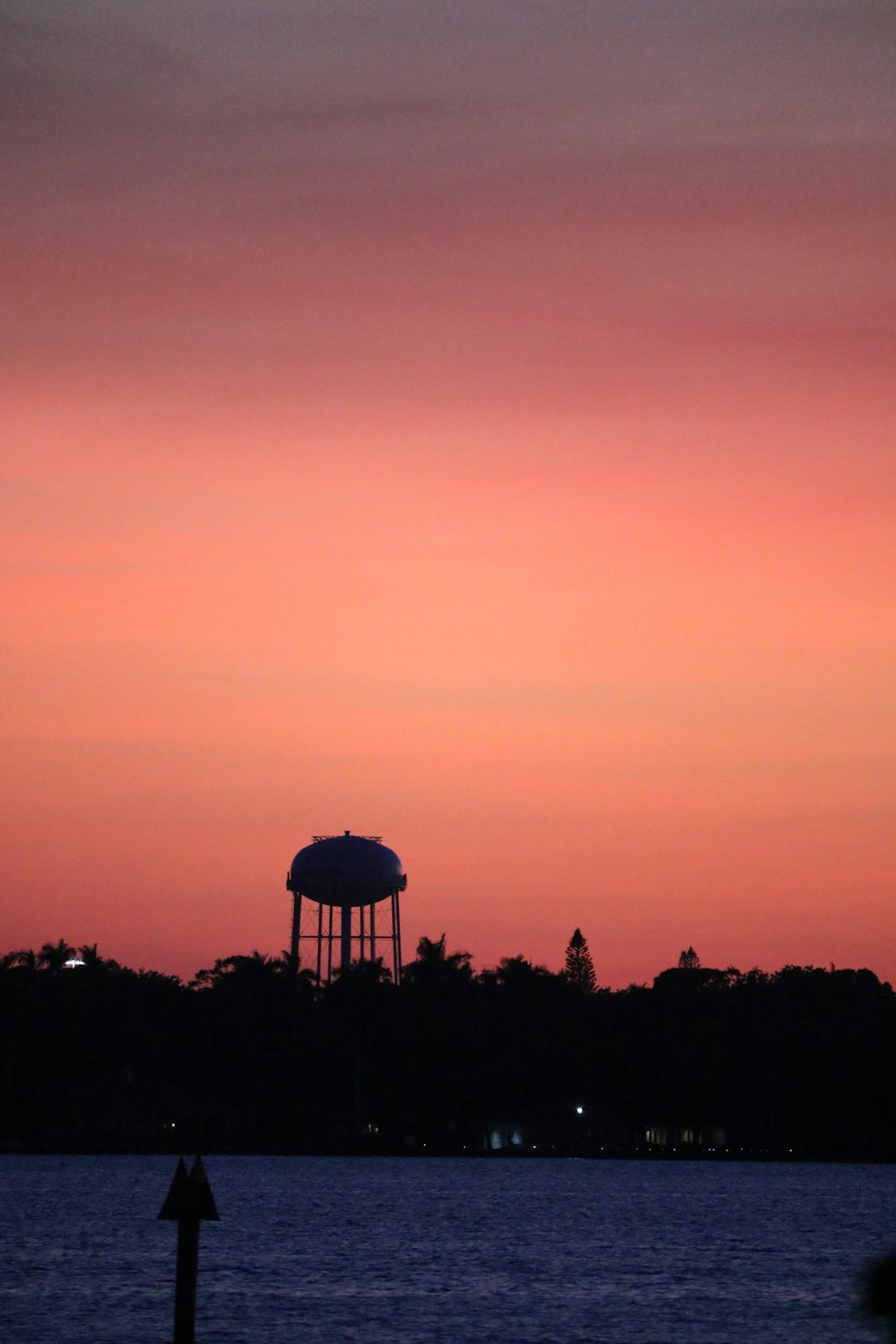 a large body of water with a water tower in the background