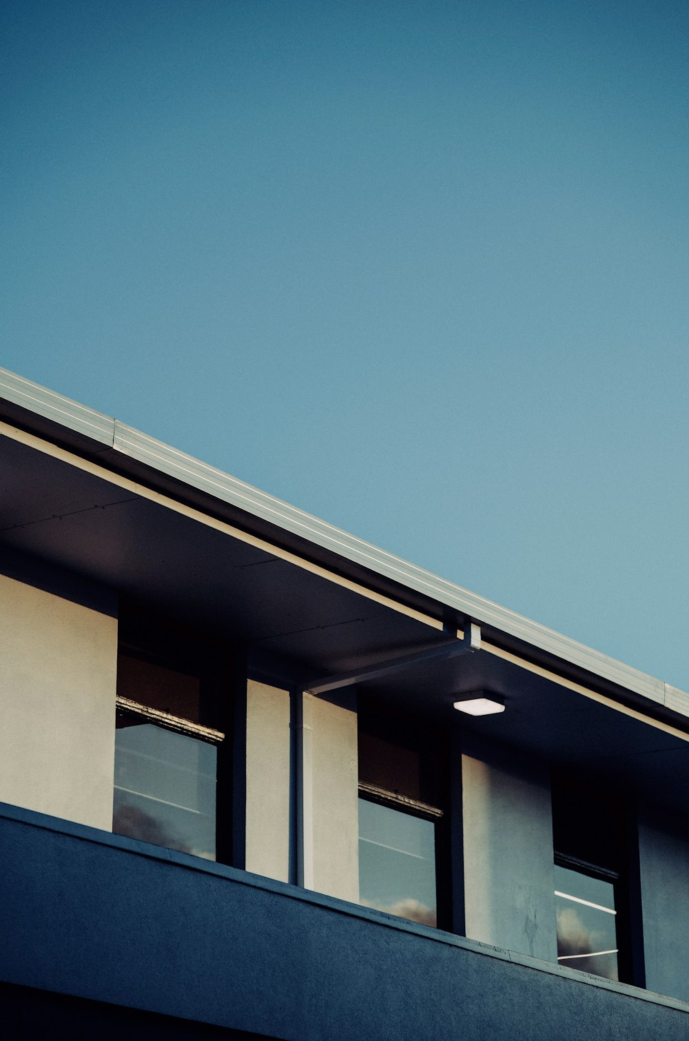 an airplane flying over a building with windows