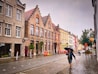 a woman walking down a street holding an umbrella