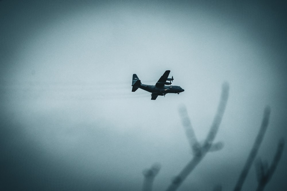 a small plane flying through a foggy sky