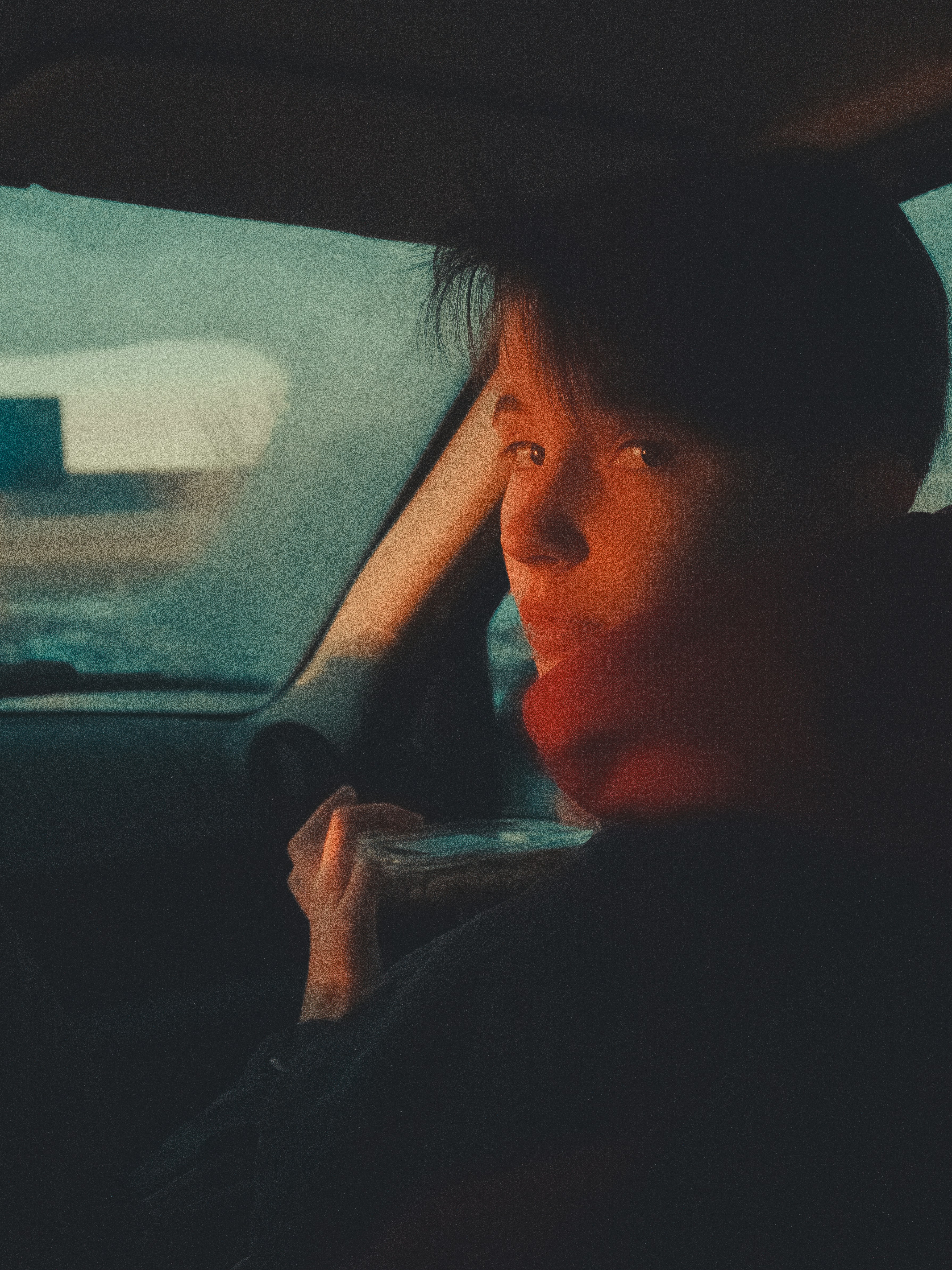 A person looks back from inside of a car.