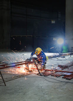 a man in a hard hat working on a piece of metal