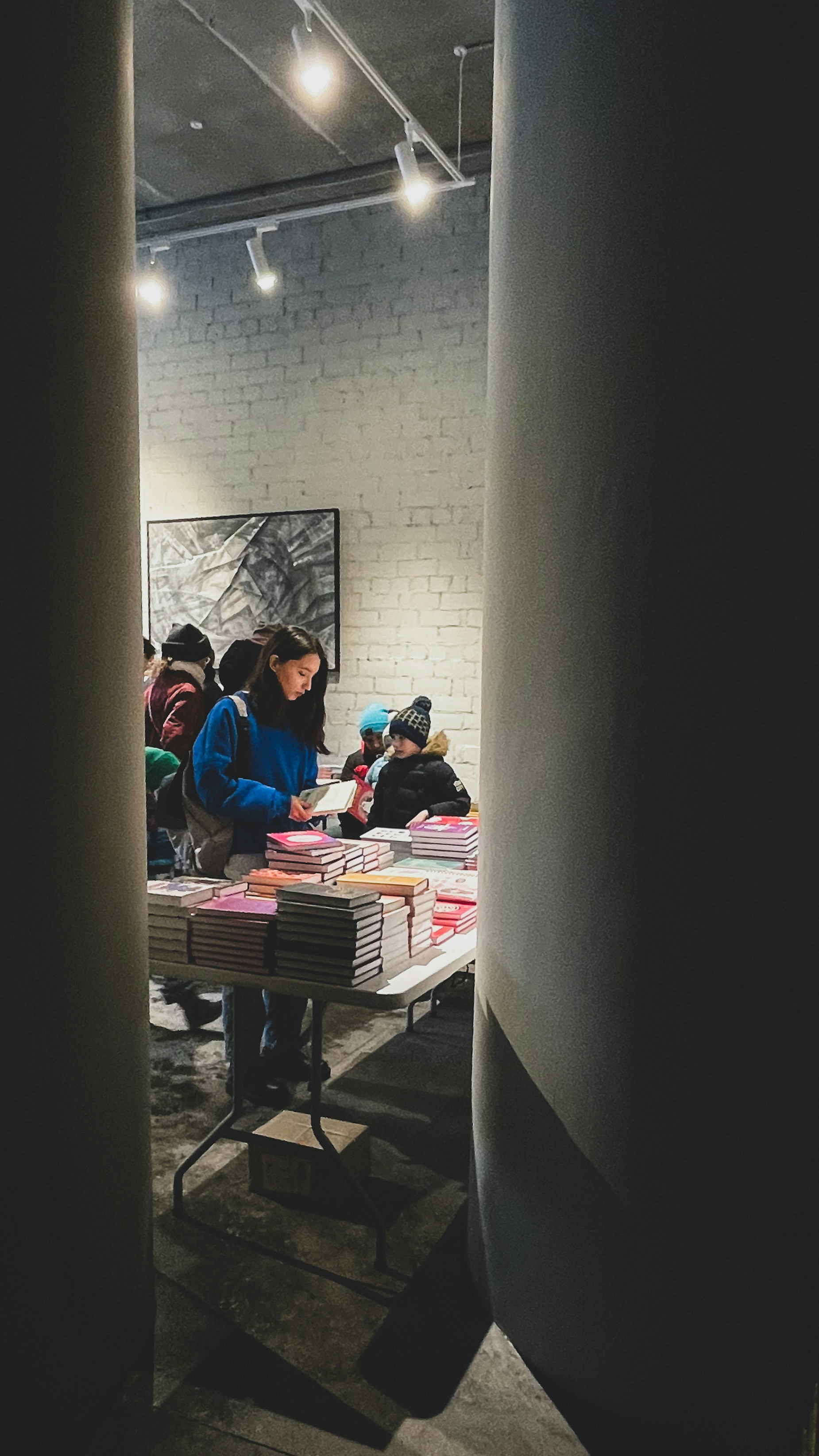 People look at books displayed at a book signing.