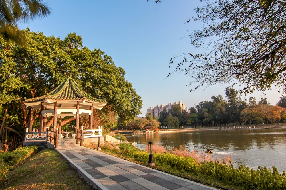 a gazebo in a park next to a body of water