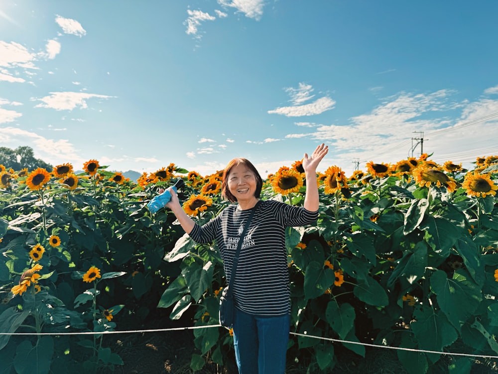 a woman standing in front of a field of sunflowers