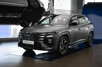 a grey suv is on display in a showroom