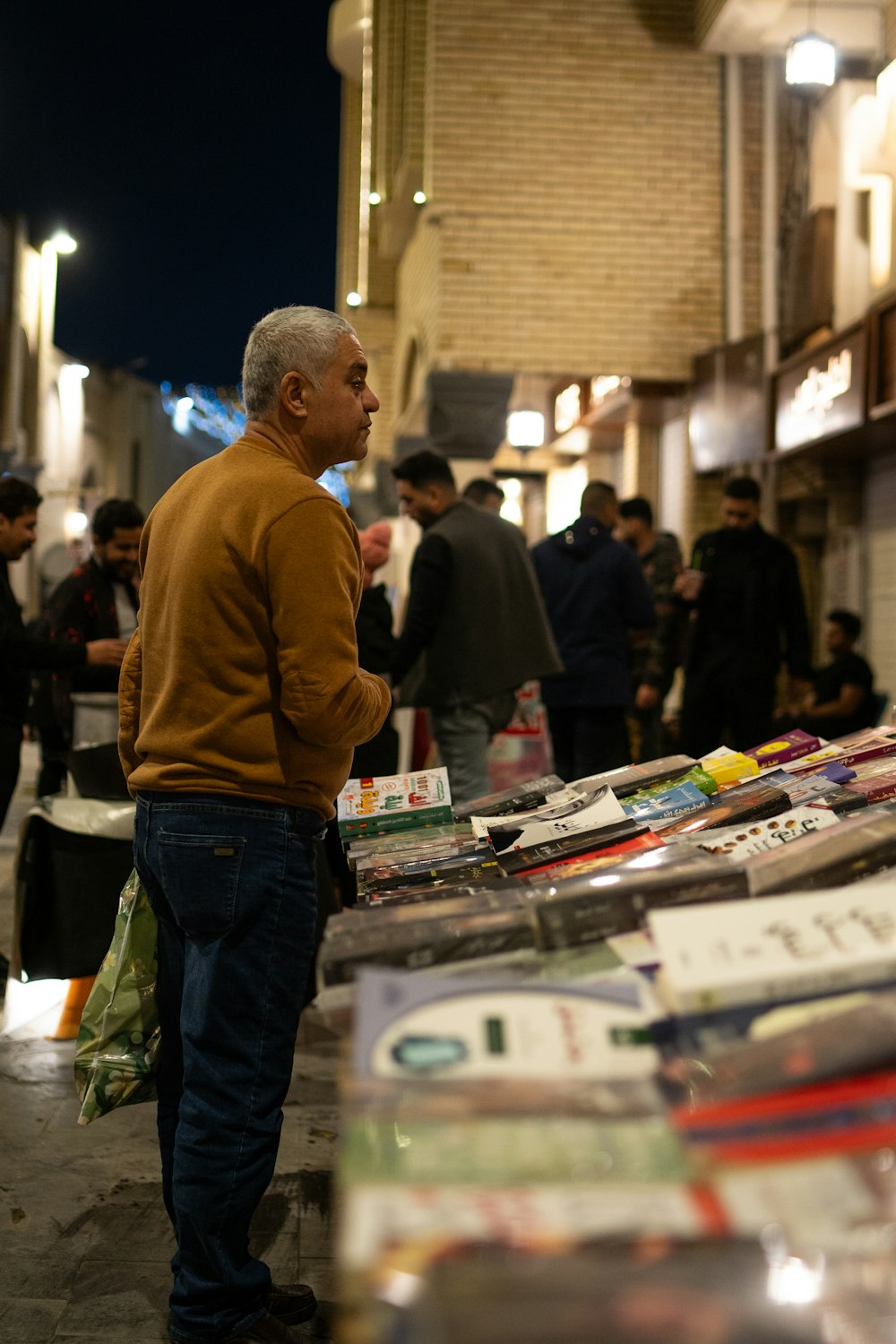 a man standing next to a table full of books