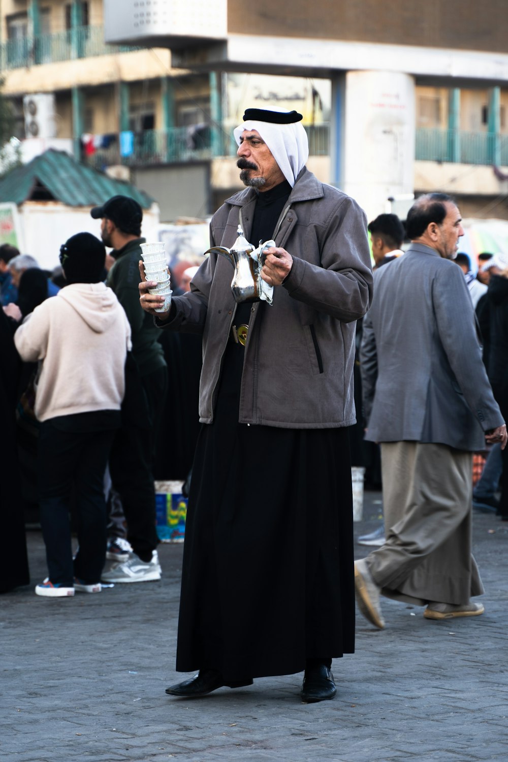 a man in a long black dress and a man in a white headdress