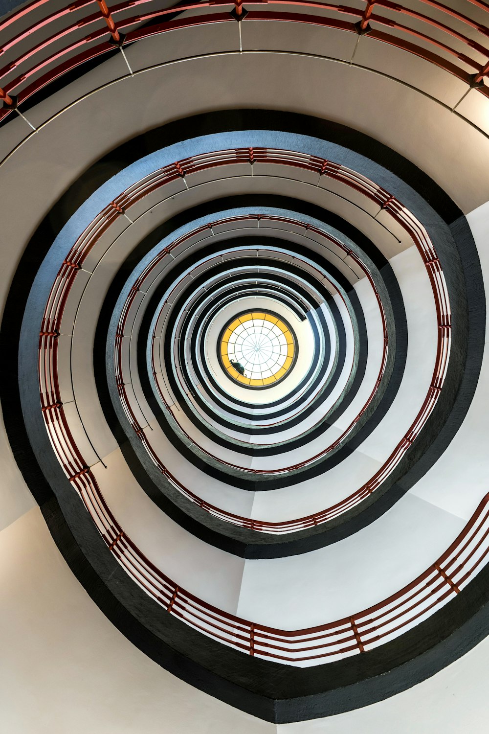 a spiral staircase with a clock in the center