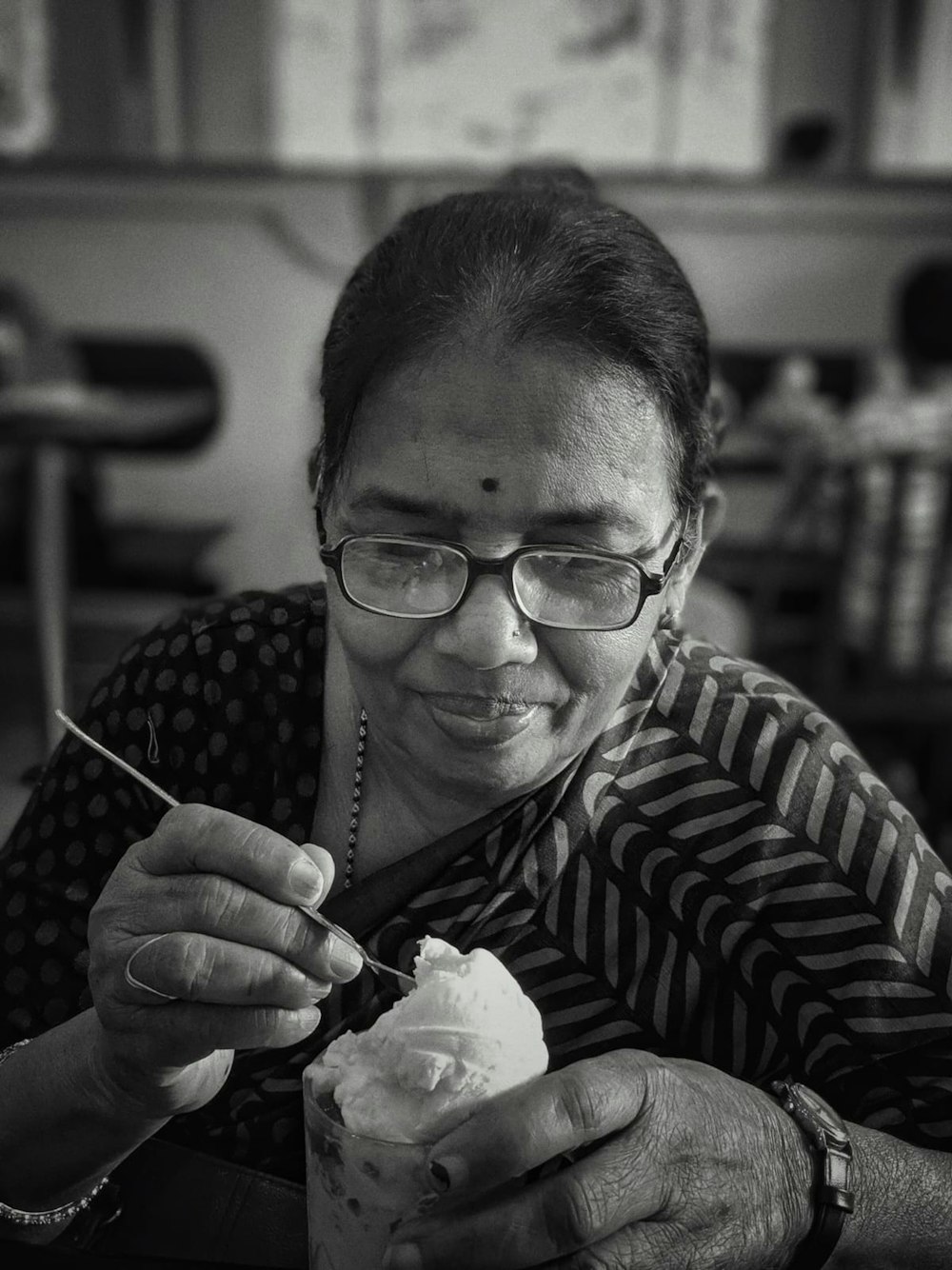 a black and white photo of a woman eating ice cream