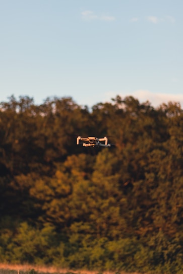 a small airplane flying over a lush green forest