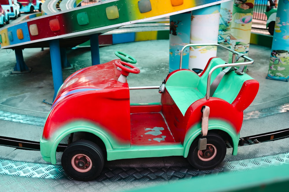 a red and green toy car on a toy track