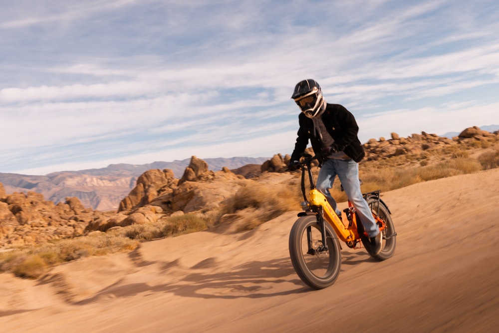 a man riding a bike down a dirt road