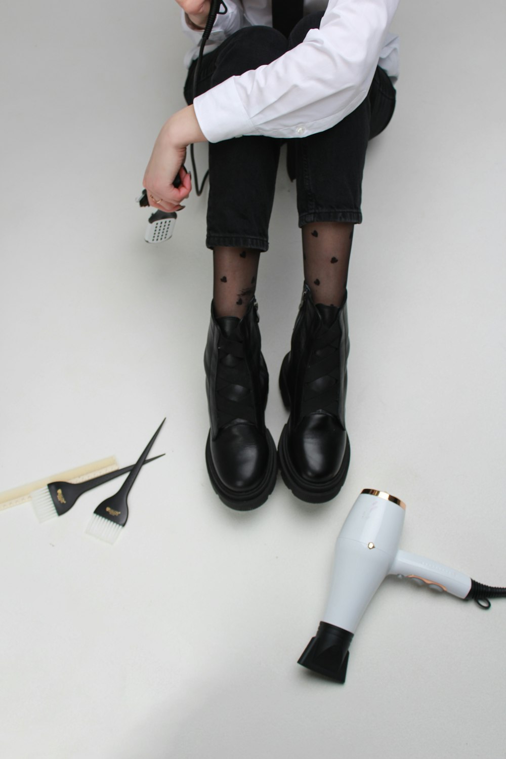 a young boy sitting on the floor with a hair dryer and scissors