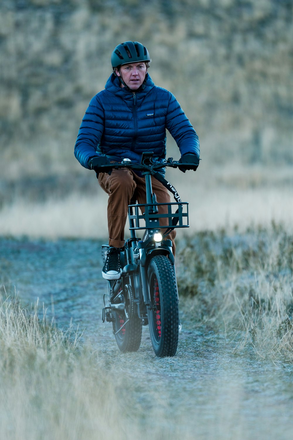 a man riding a bike down a dirt road