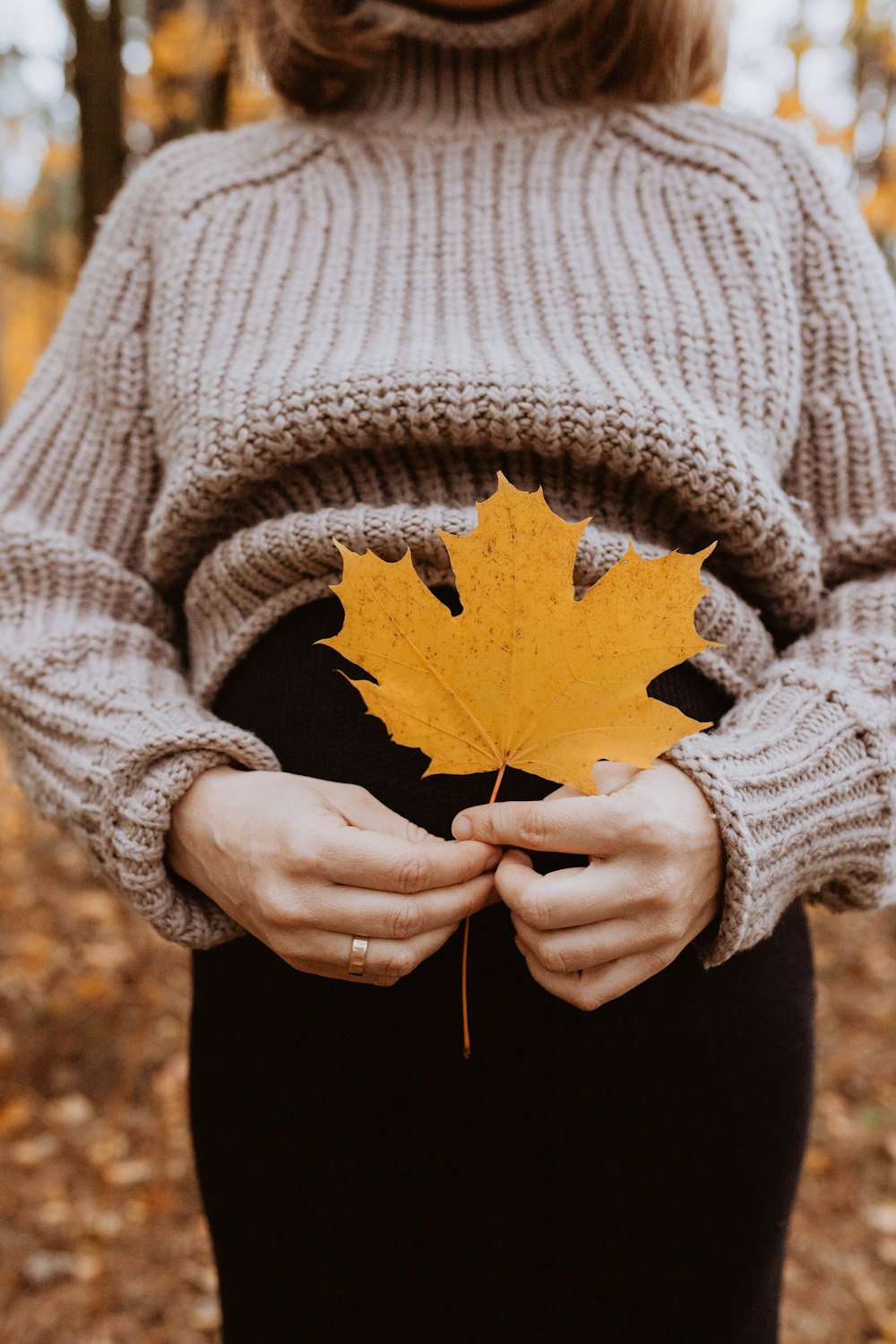 a woman holding a maple leaf in her hands