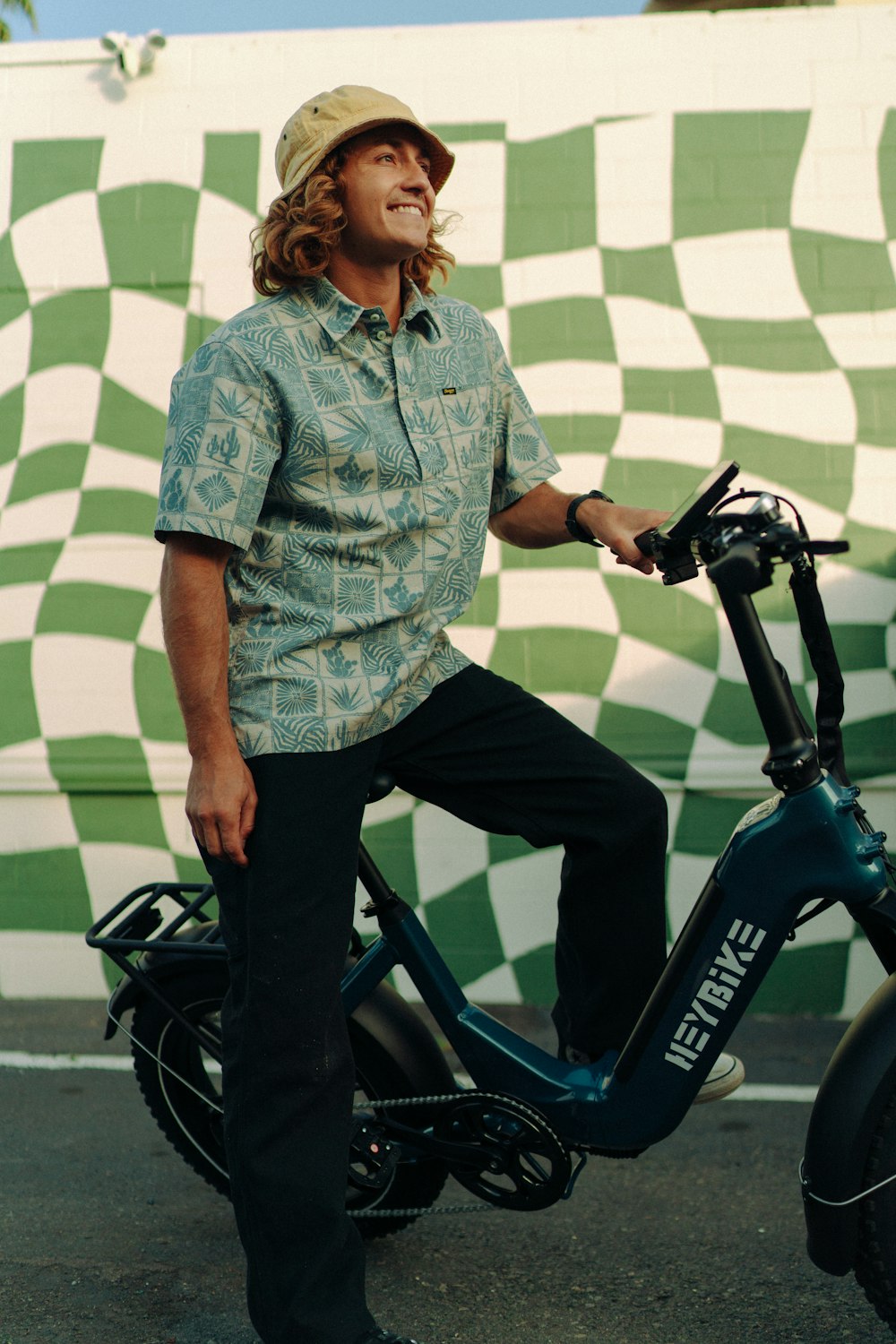 a man standing next to a scooter in front of a wall