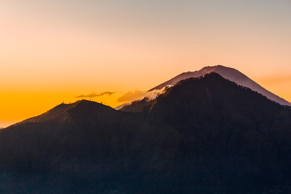 a mountain covered in snow at sunset