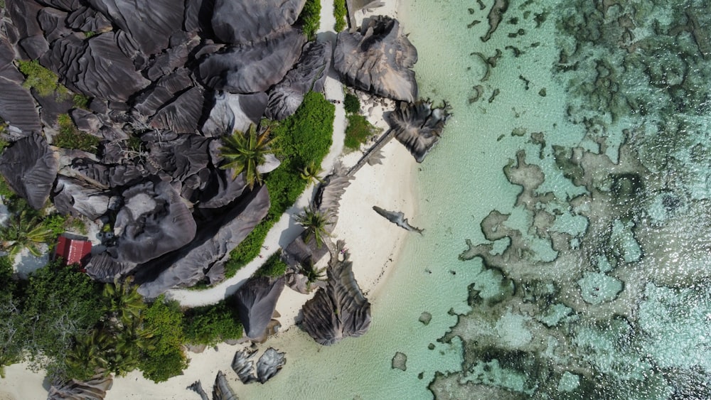 an aerial view of a beach with rocks and water