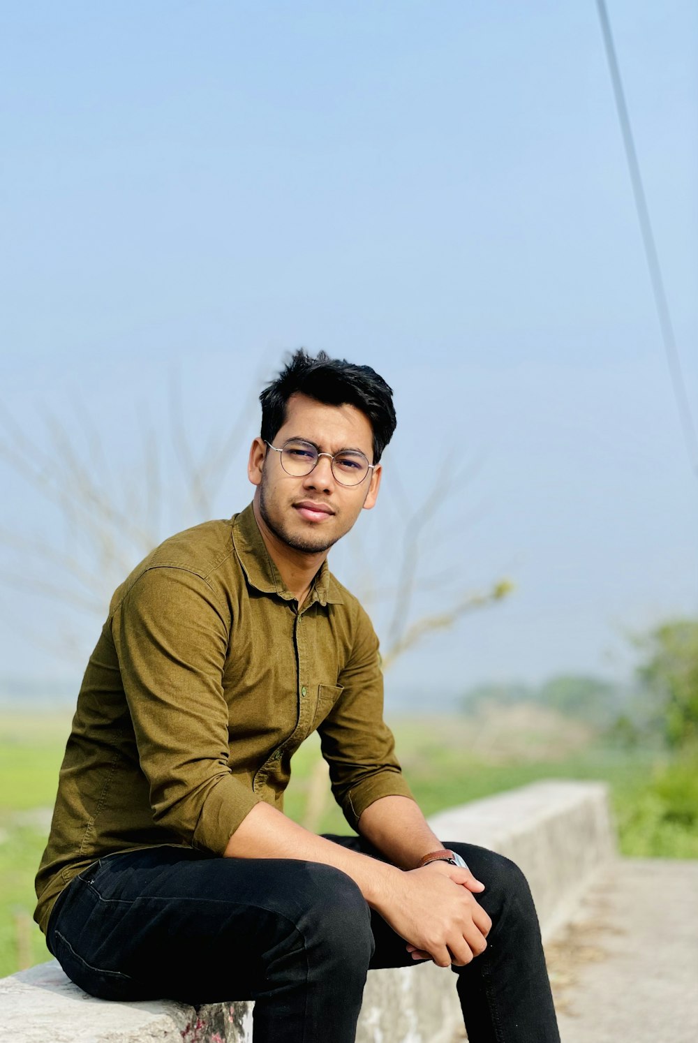 a man sitting on a wall with his legs crossed