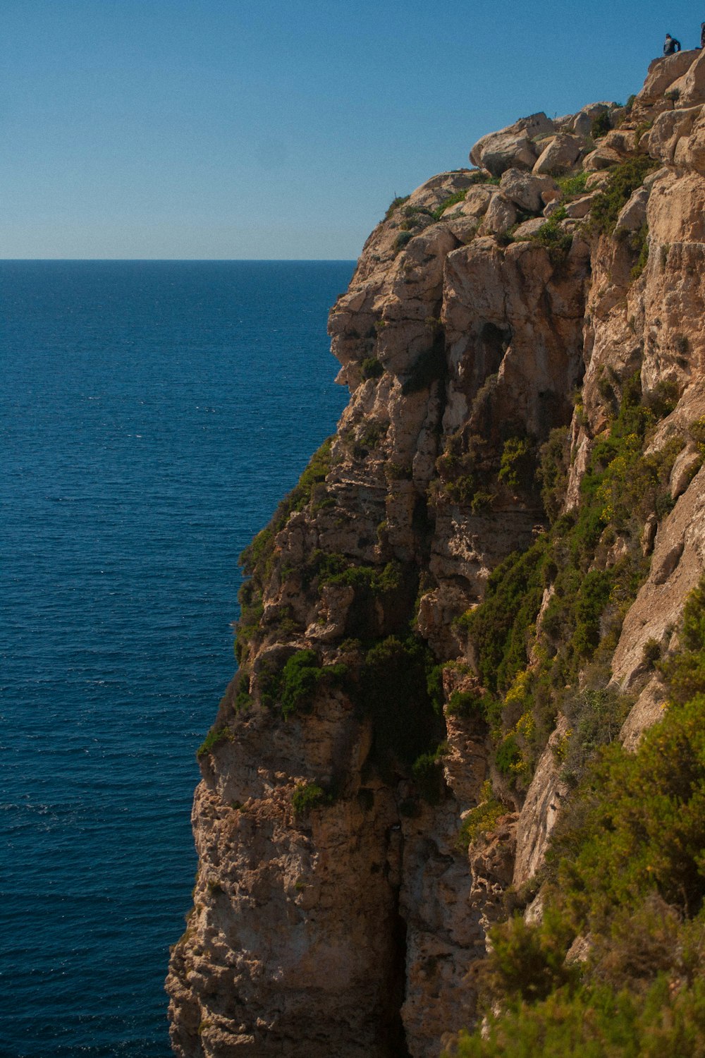 a man riding a surfboard on the edge of a cliff