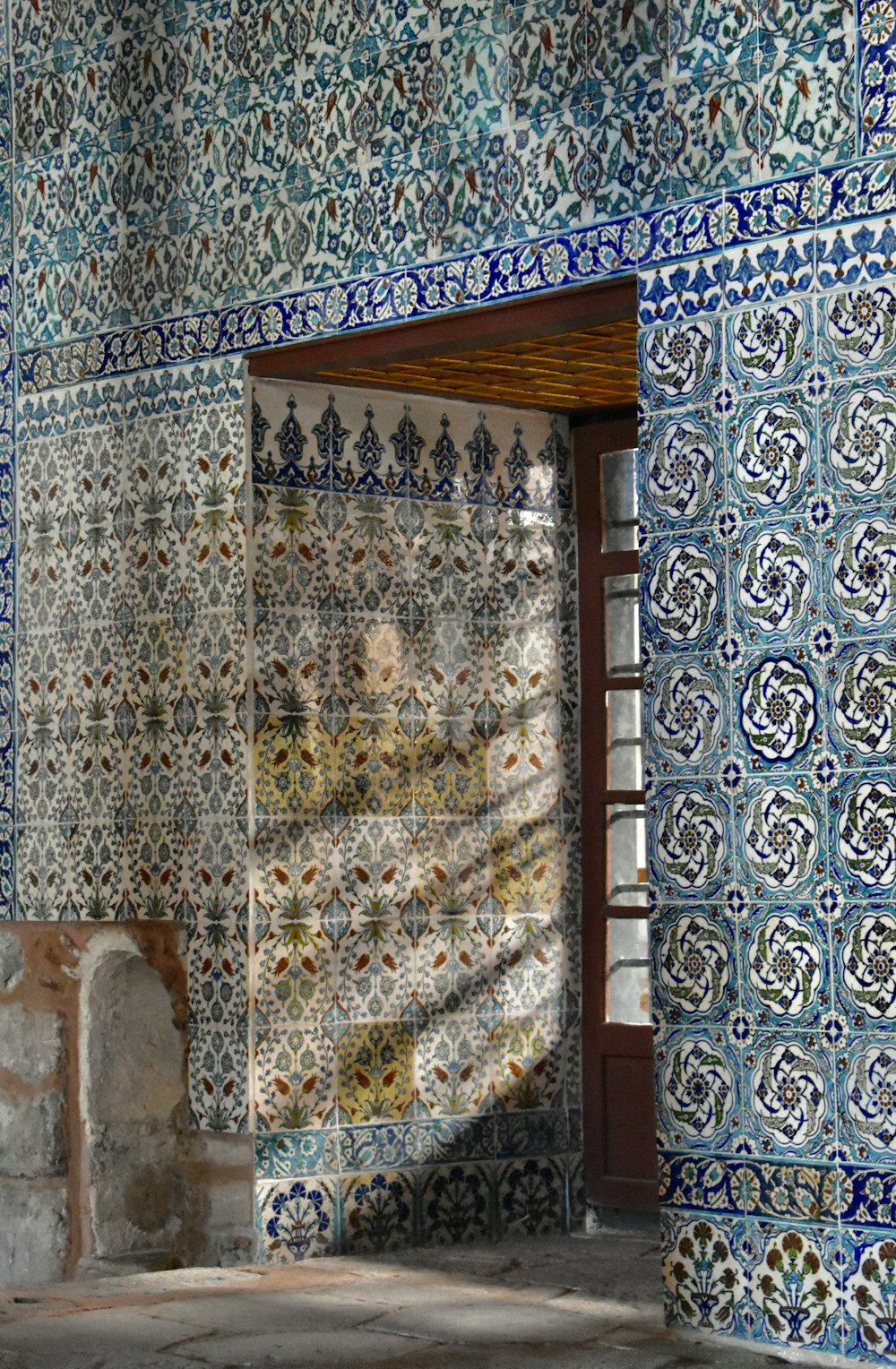 an open door in a room with blue and white tiles
