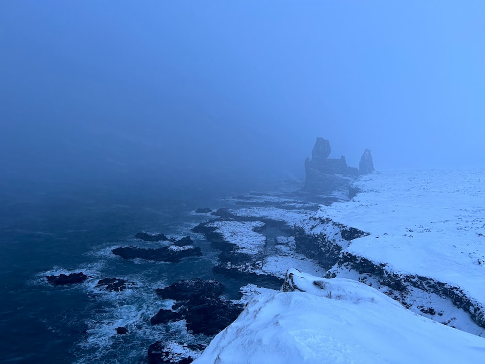 a foggy day on the coast of a body of water