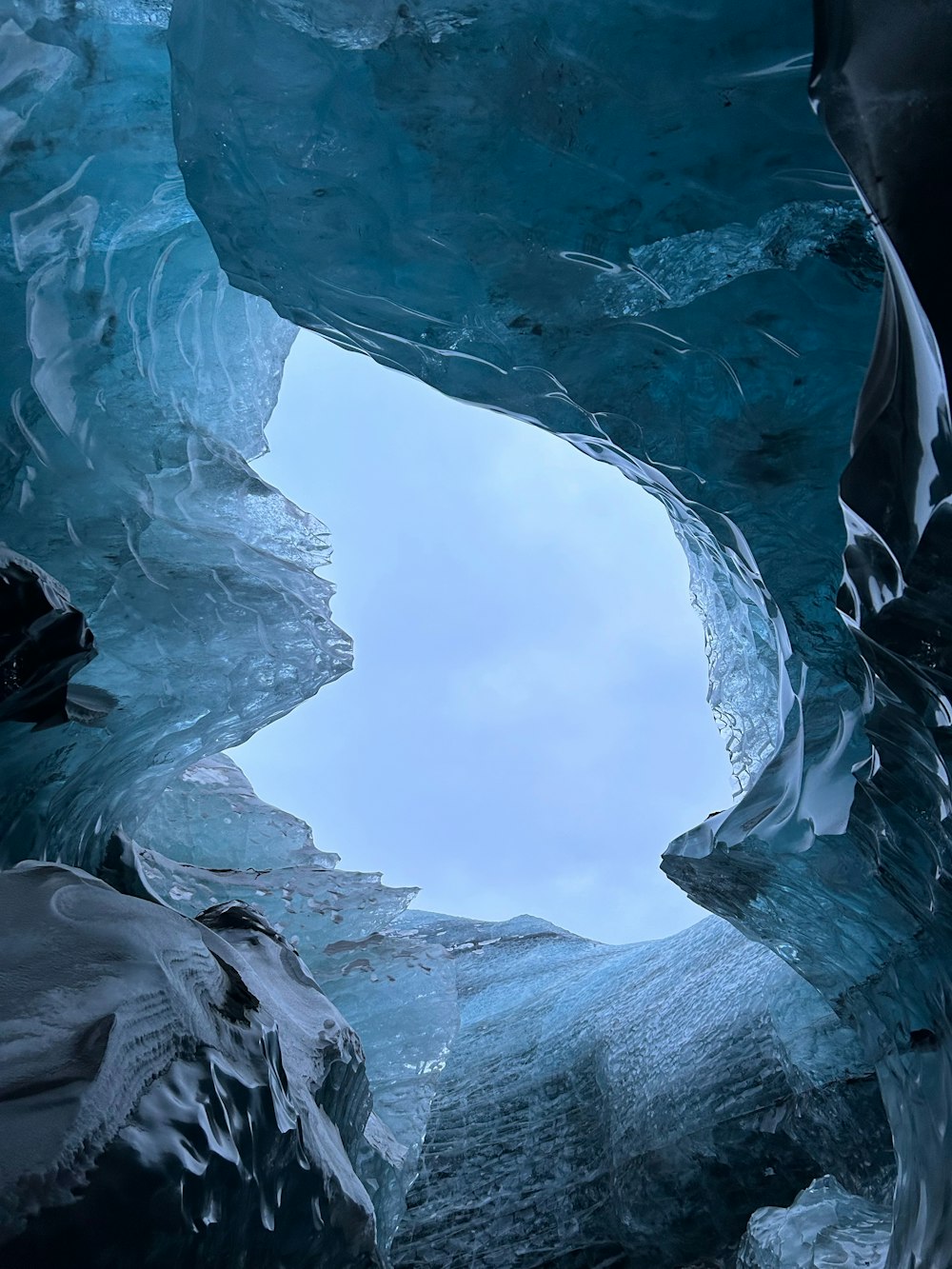 a large ice cave with a sky in the background