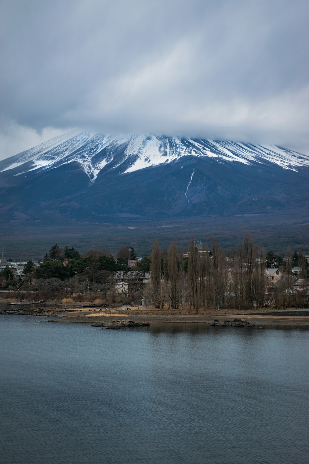 a large snow covered mountain towering over a city