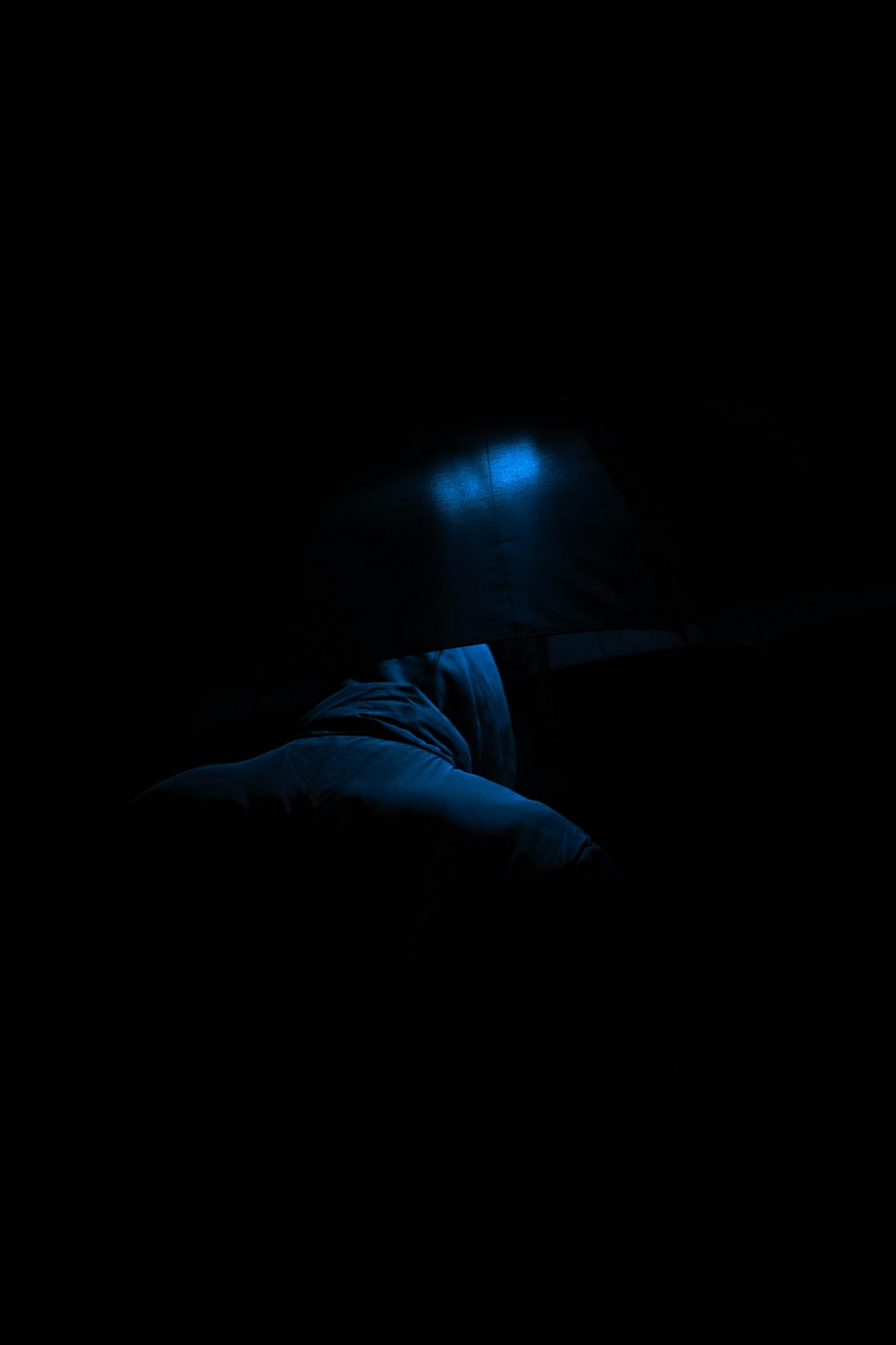 a person laying in a bed in the dark