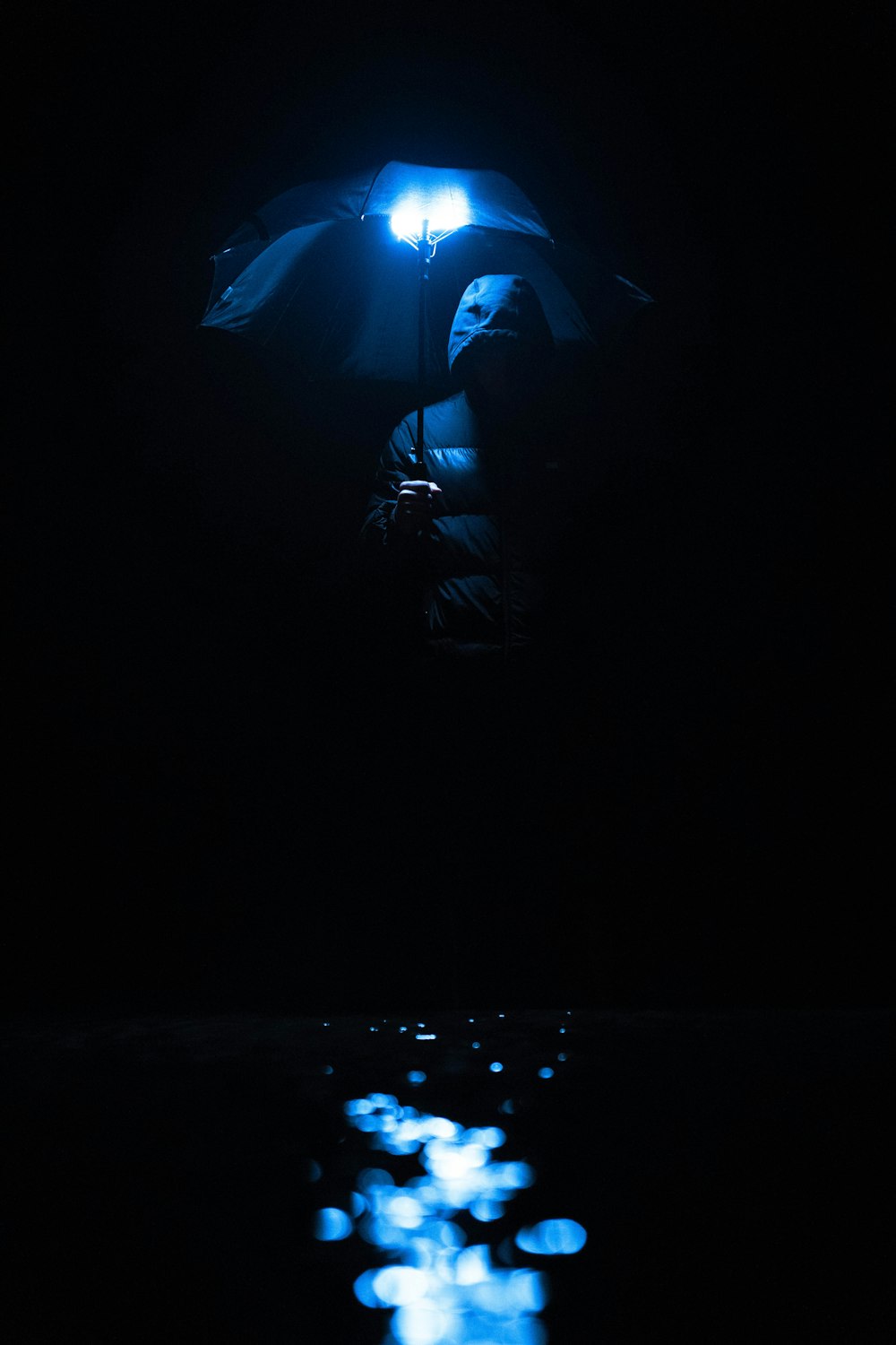 a person holding an umbrella in the dark