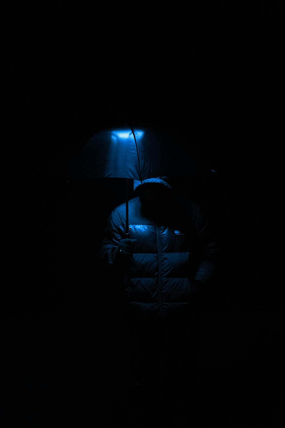 a person holding an umbrella in the dark