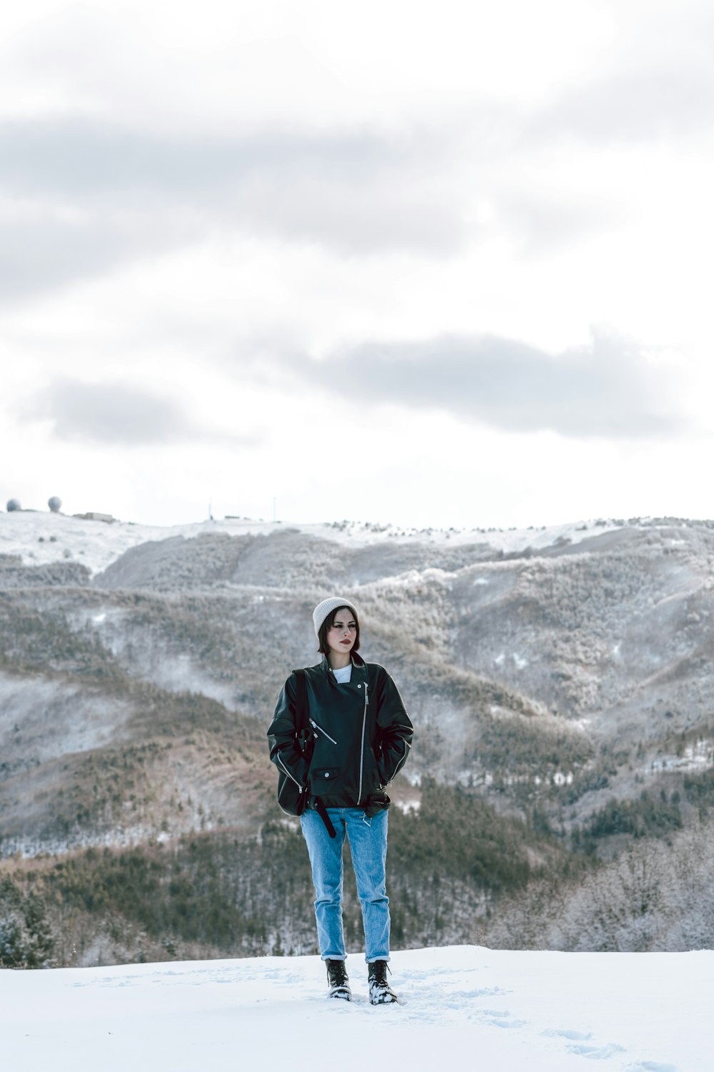 a man standing on top of a snow covered slope