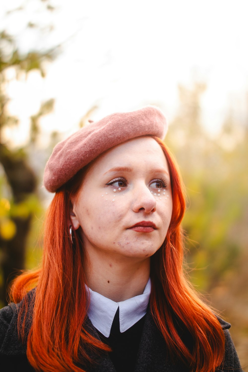 a woman with red hair wearing a hat