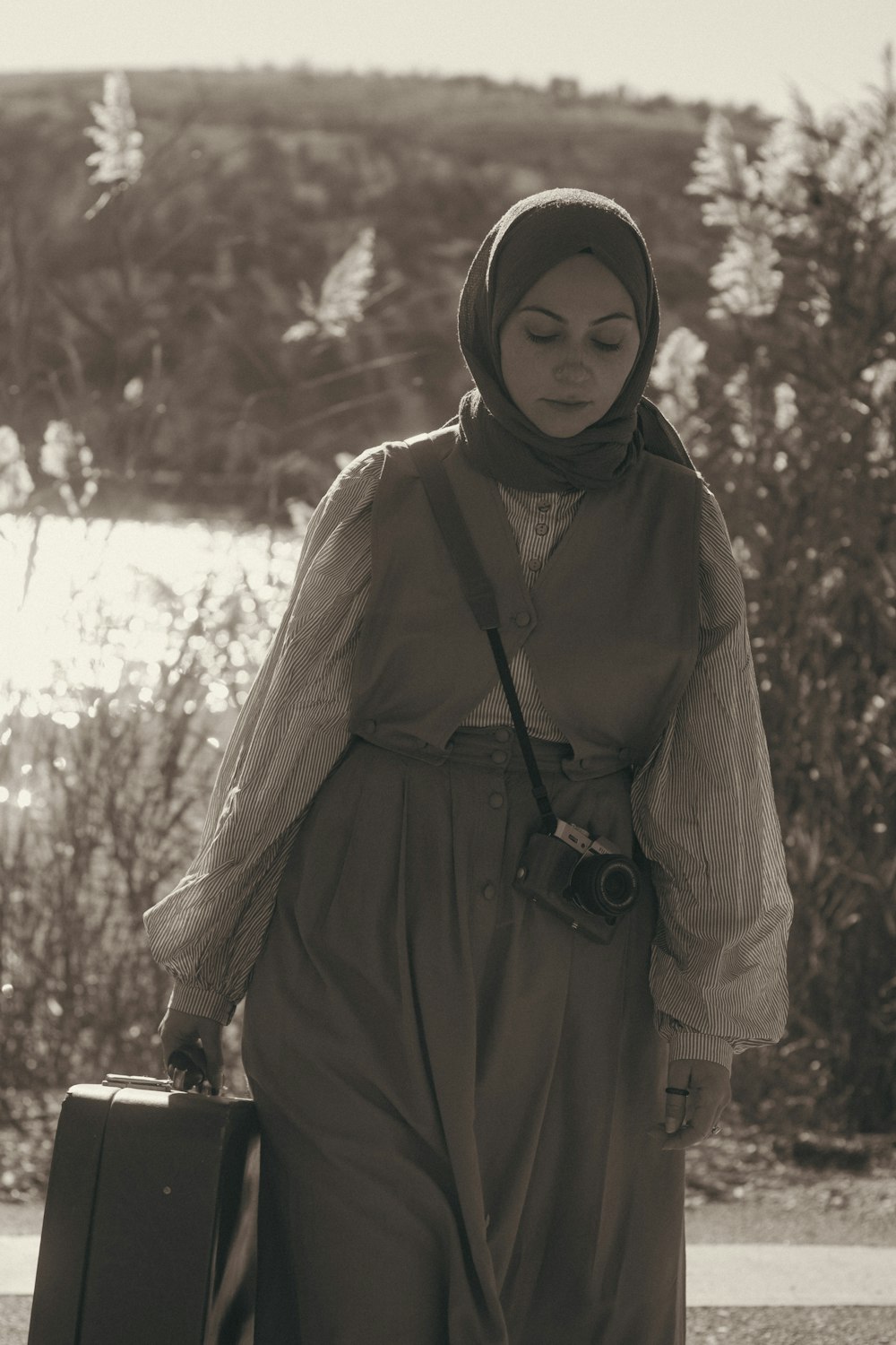 une femme en hijab portant une valise