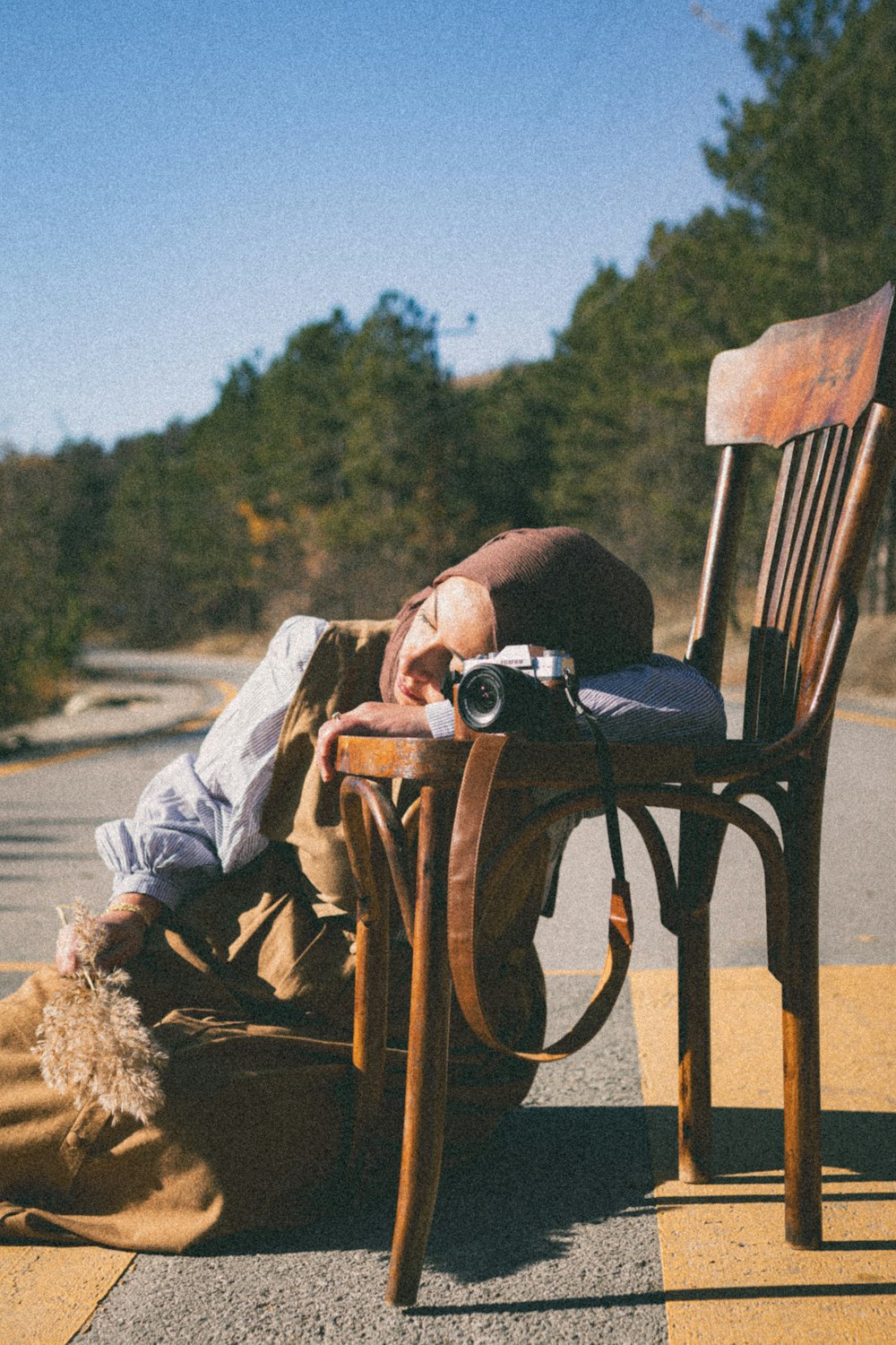 a man laying on the ground next to a wooden chair