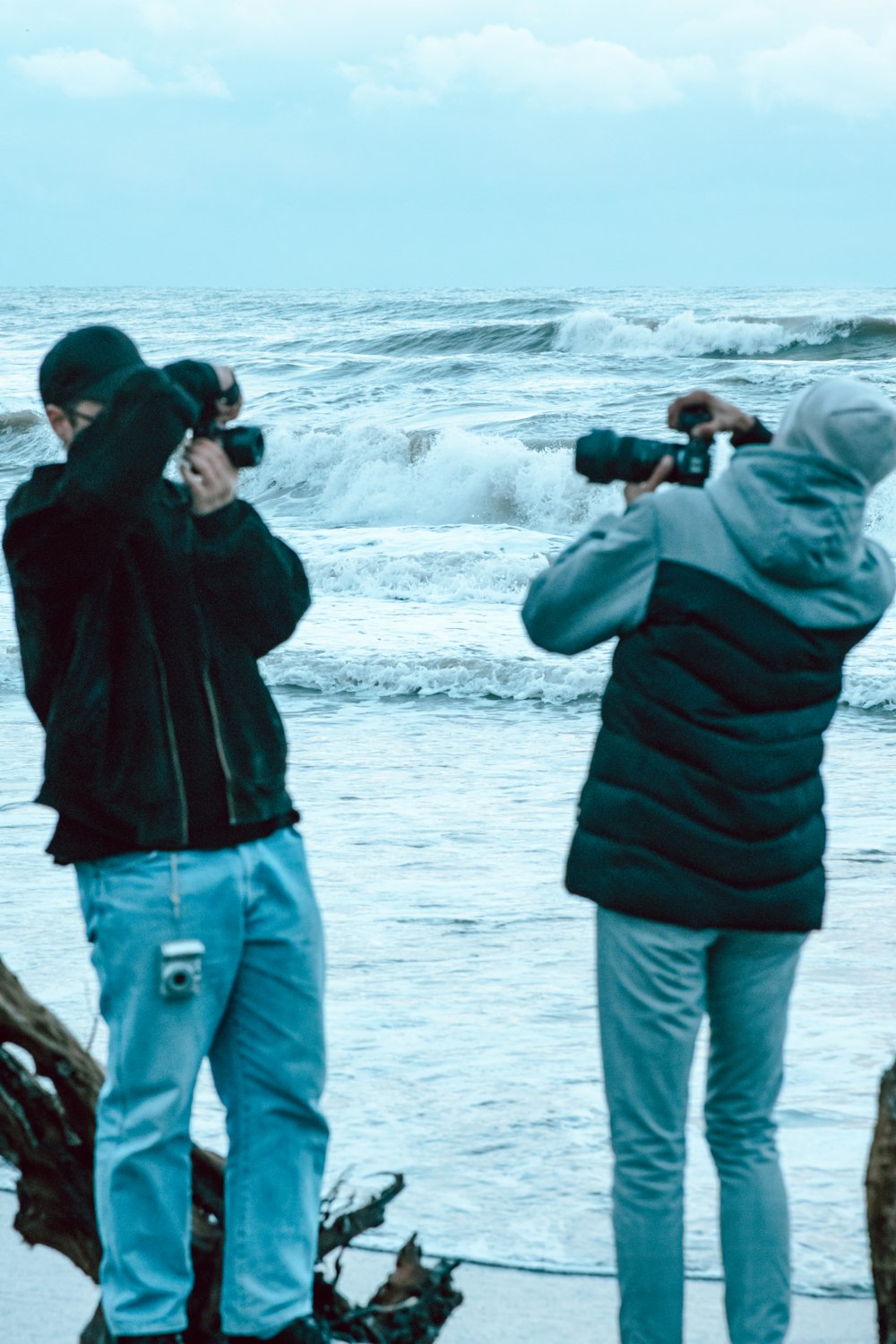 a couple of people standing on top of a beach