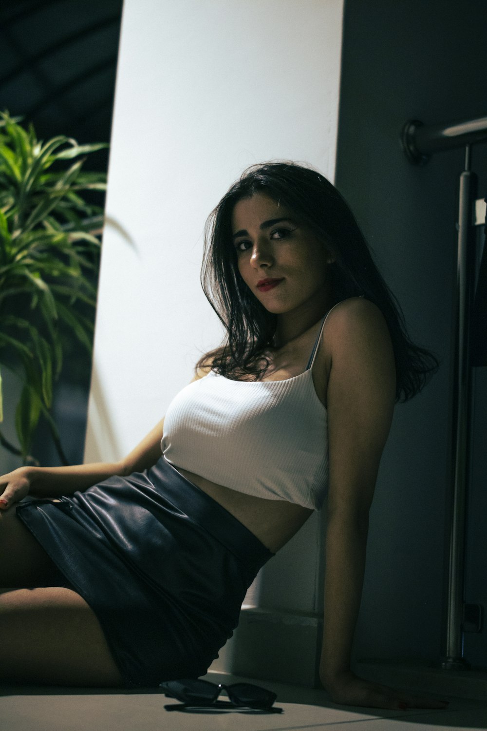 a woman sitting on the floor in a white top