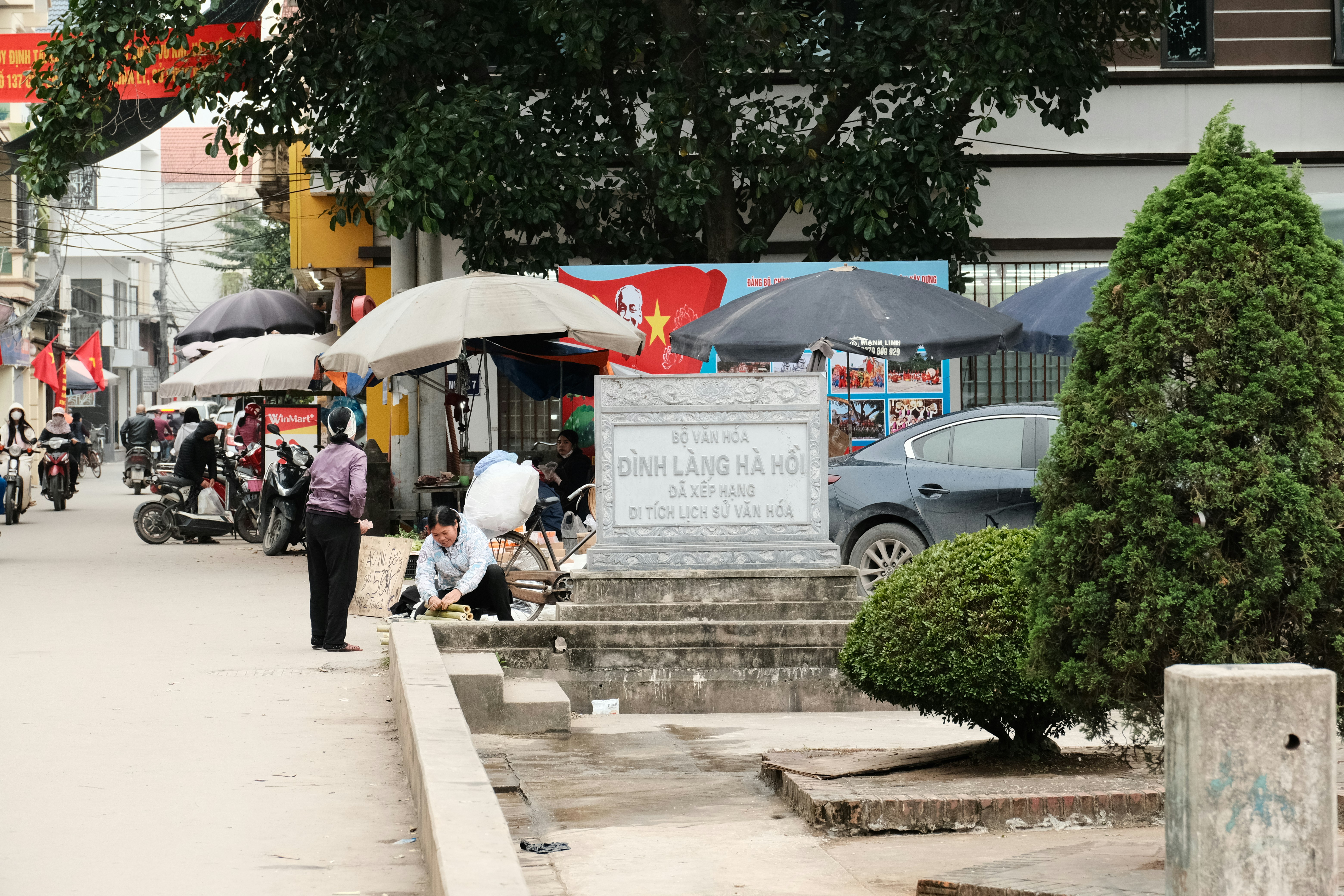 एक ध्वस्त माओवादी शहीद स्मारक के मलबे की तस्वीर, जिसके पास पुलिसकर्मी खड़े हैं।