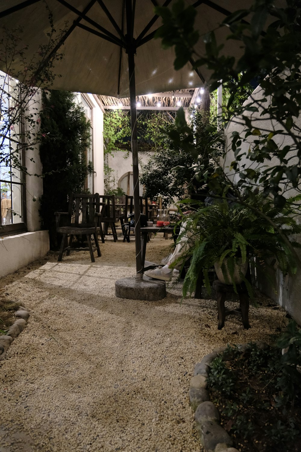 un patio avec une table, des chaises et un parasol