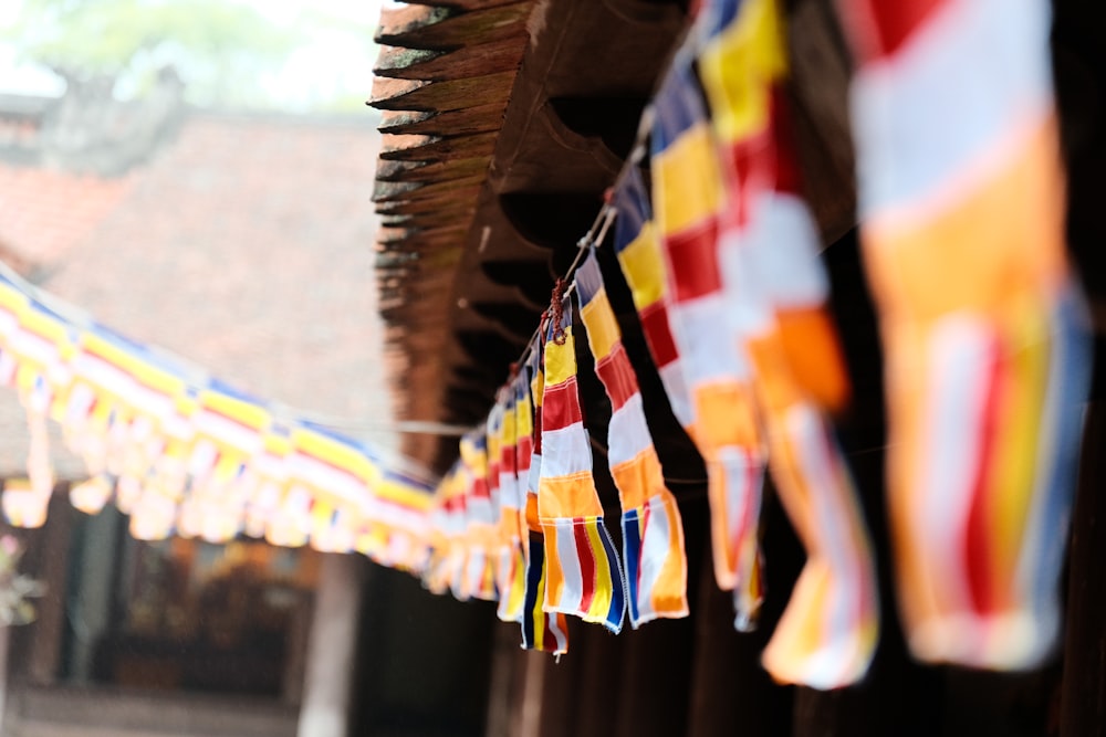 a row of colorful flags hanging from the side of a building