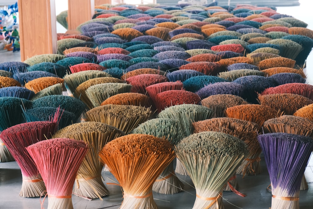 a bunch of colorful brooms sitting on the ground