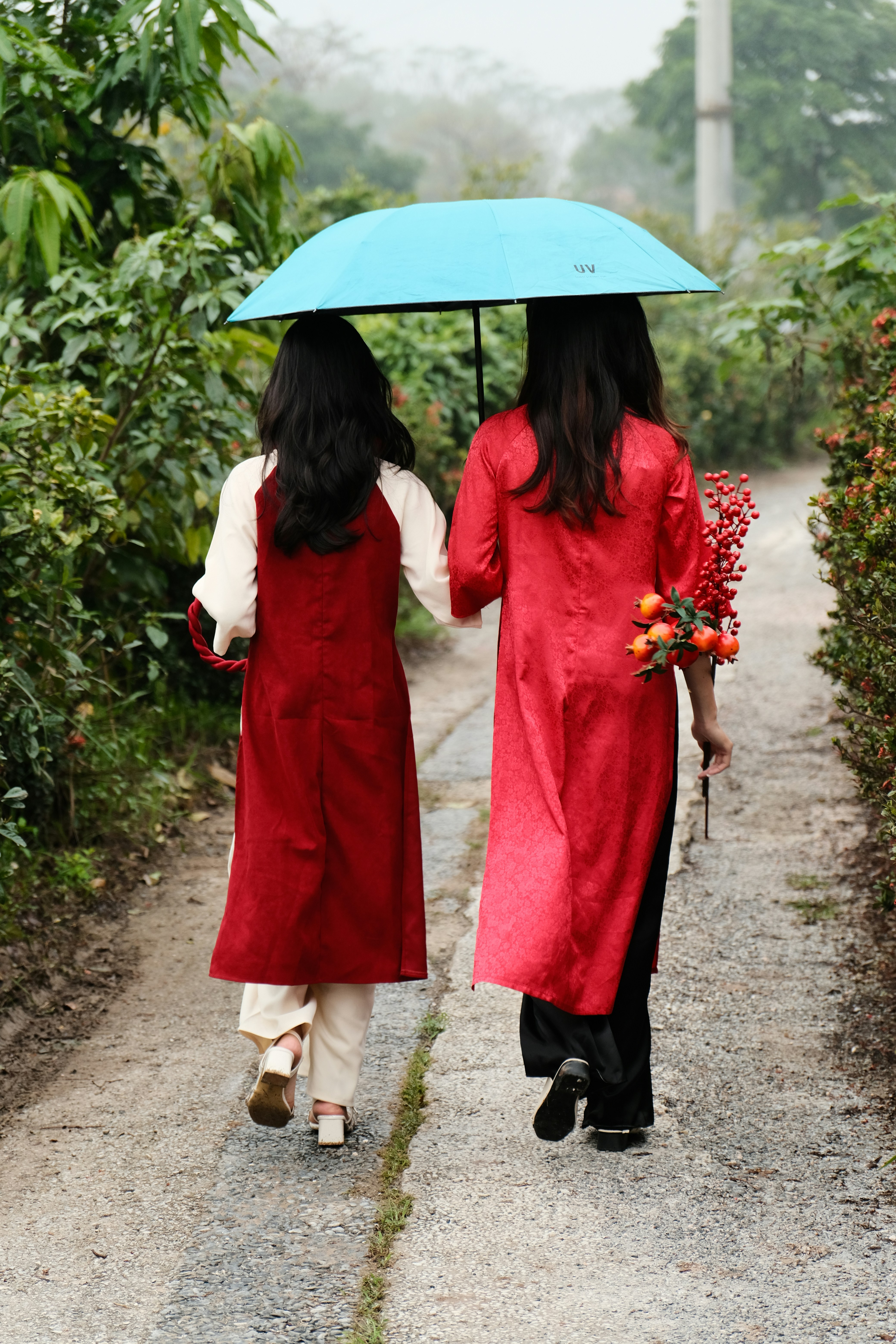 Zwei Frauen, die einen Weg mit einem Regenschirm in der Hand entlanggehen  Foto – Kostenloses Bild zum Thema Porträt auf Unsplash, image size:3000x4500
