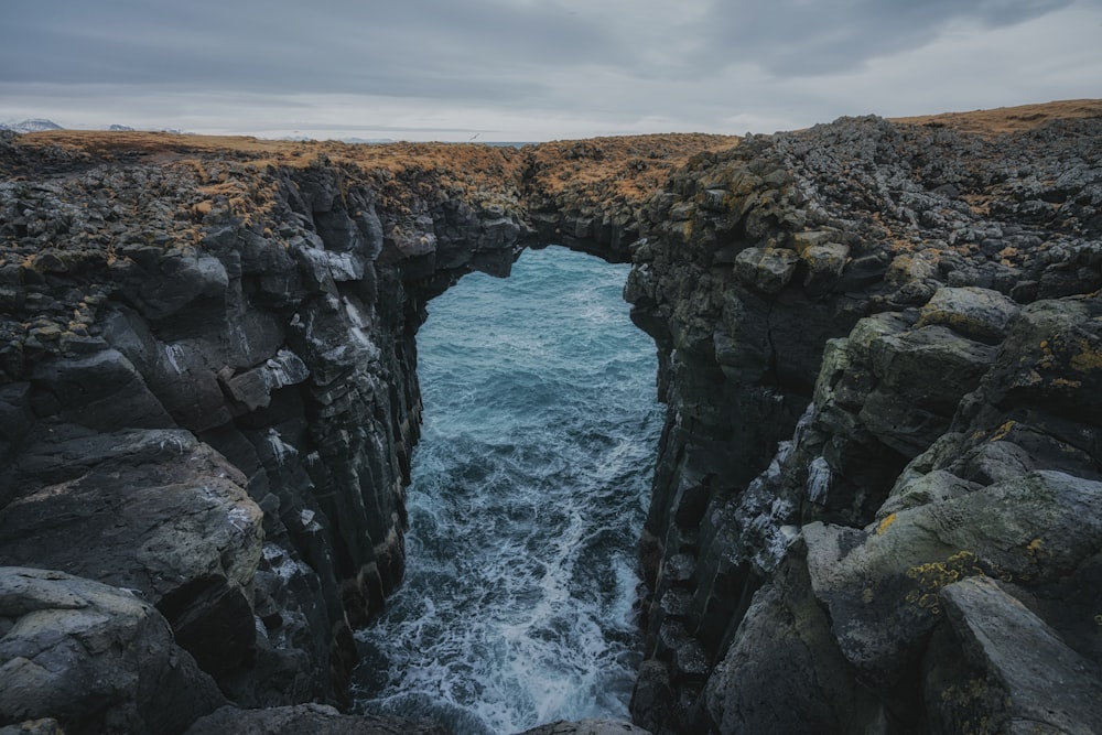 a rocky cliff with a hole in the middle of it