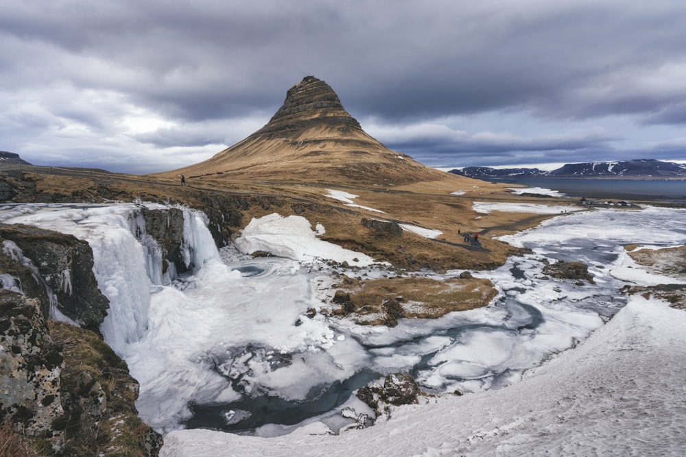 a very tall mountain with ice on the ground