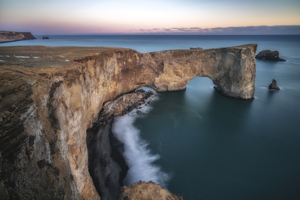 a rocky cliff with a large body of water