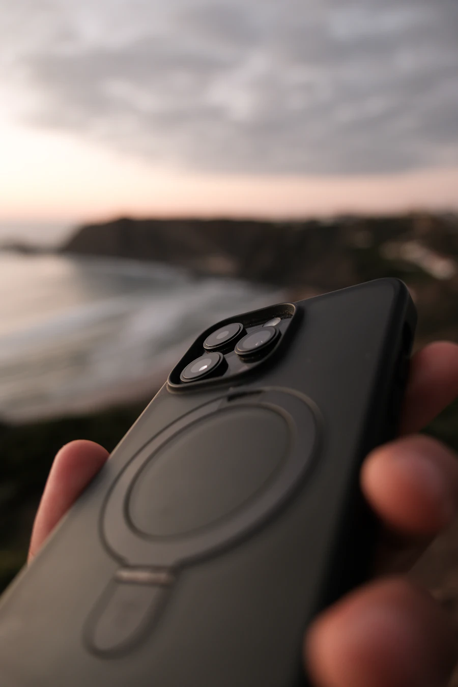Person using an iPhone outdoors, representing everyday photo-taking that produces HEIC files needing conversion before sharing