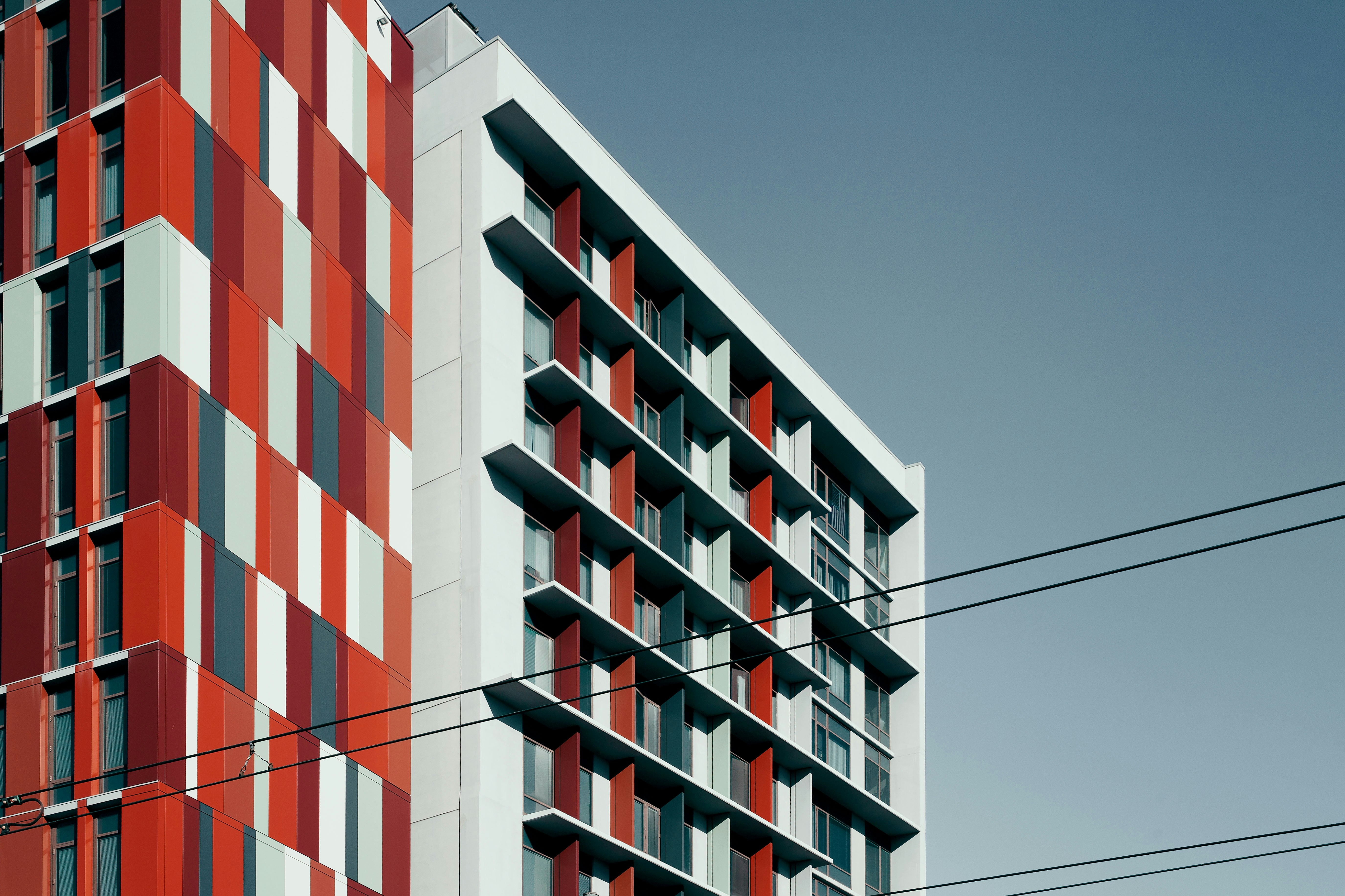 a tall red and white building next to a tall red and white building