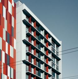 a tall red and white building next to a tall red and white building